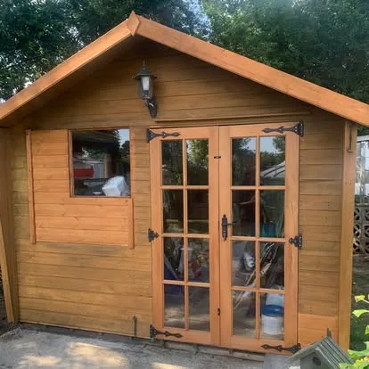 Restored timber summerhouse with new hardwood double doors and fixed windows